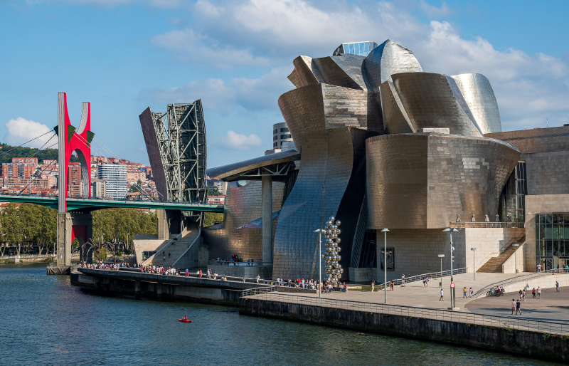 Bilbao, Guggenheim-Museum (Frank O. Gehry, 1993–1997) mit den Skulpturen von Jeff Koons, Anish Kapoor und Louise Bourgeois, Foto: Jose María Ligero Loarte / Wiki media Commons (CC BY-SA 4.0) 2021